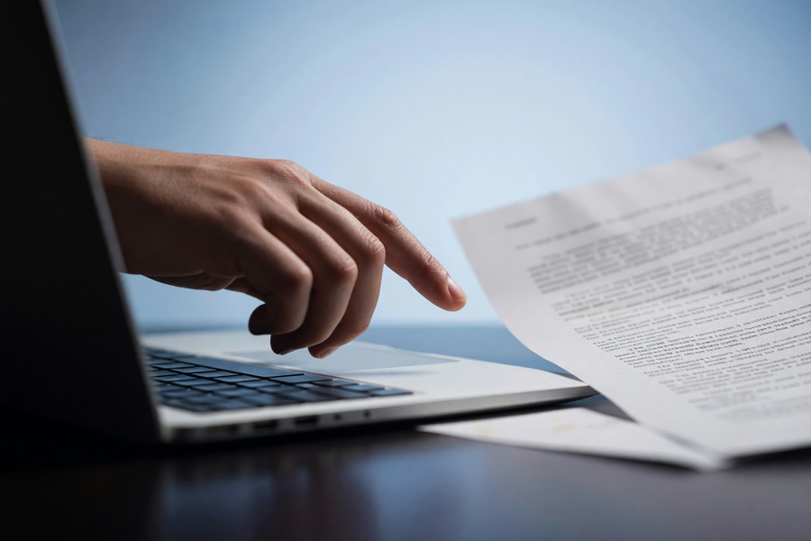 Young graduate reviewing multiple loan offers on a laptop screen