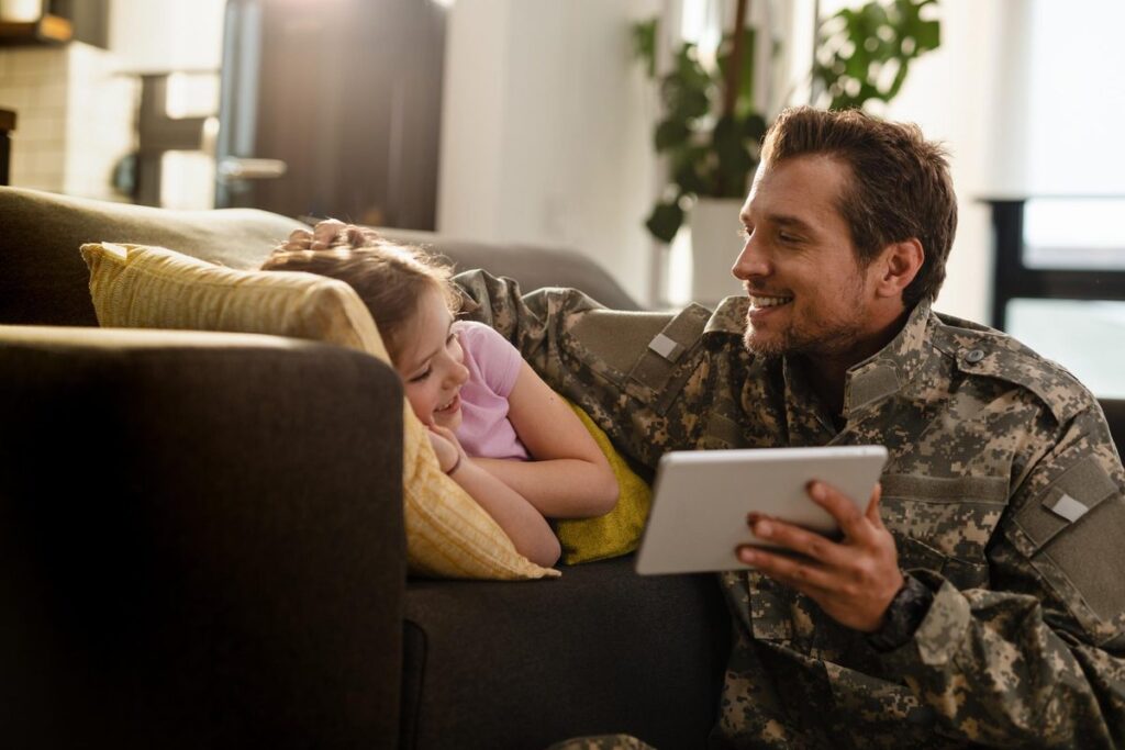 Veteran reviewing digital loan application on laptop with military service documents