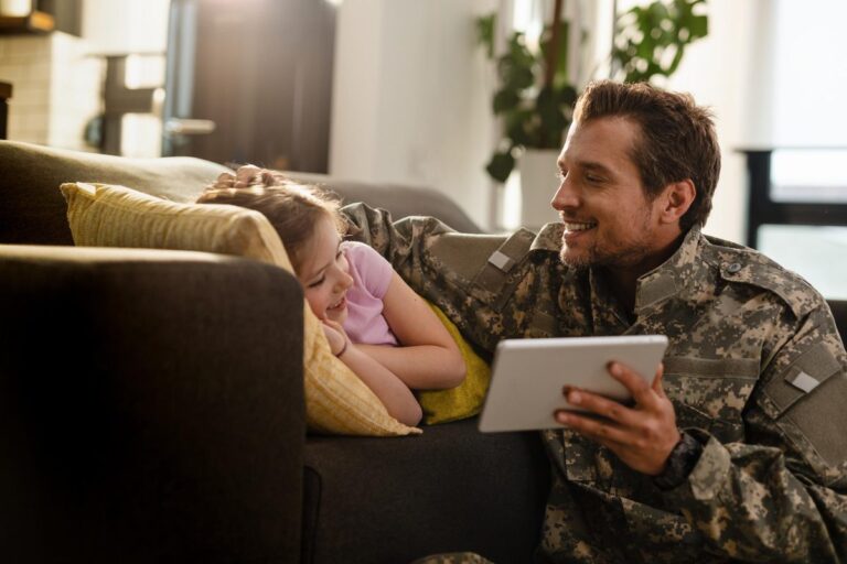 Veteran reviewing digital loan application on laptop with military service documents