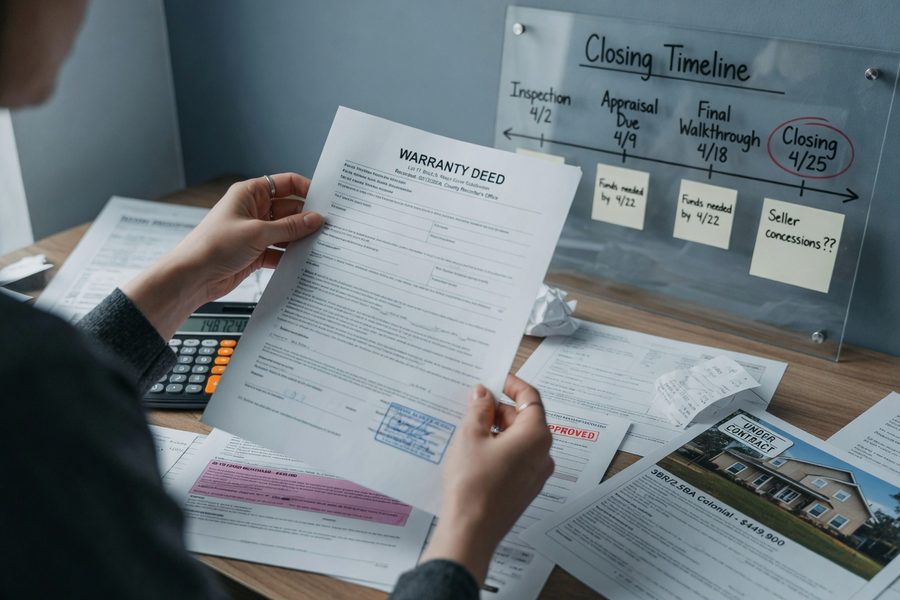 Borrower at desk reviewing step-rate loan schedule and comparing fixed-rate mortgage documents