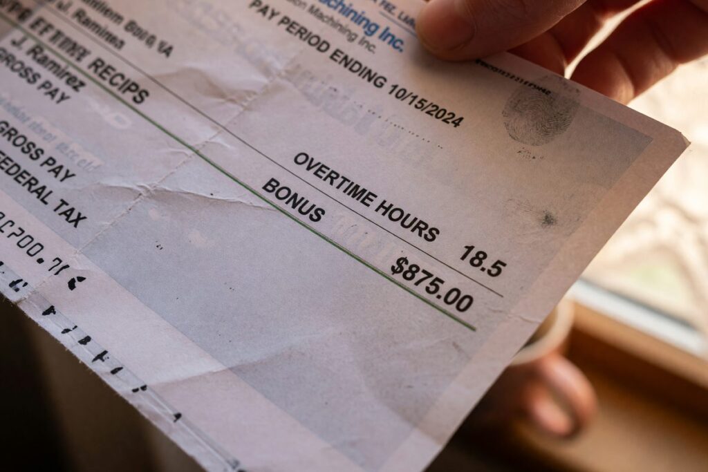 Nurse reviewing pay stub showing base salary and overtime earnings for mortgage application