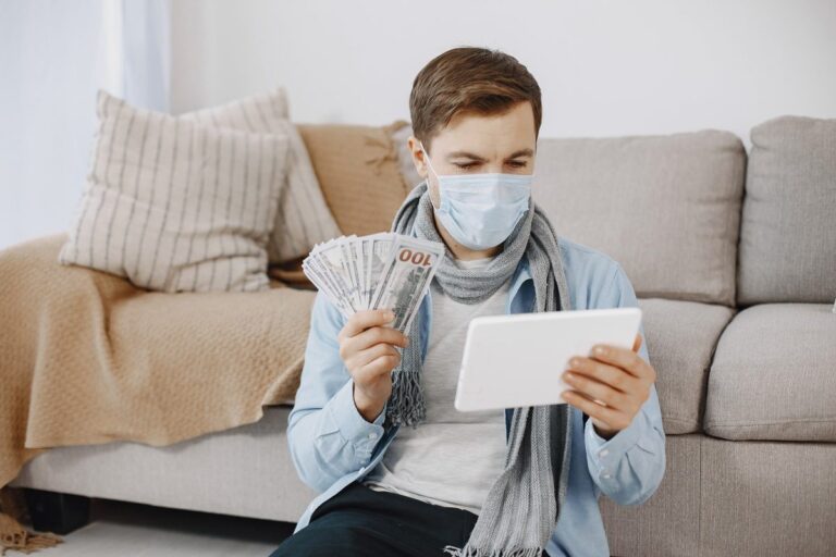 Person reviewing loan documents on a laptop while managing health condition and income fluctuations