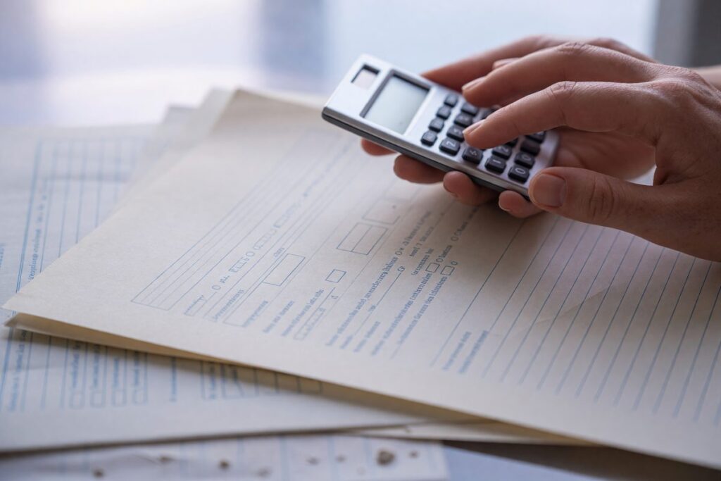 Calculator and financial documents showing debt-to-income ratio calculation for personal loan application