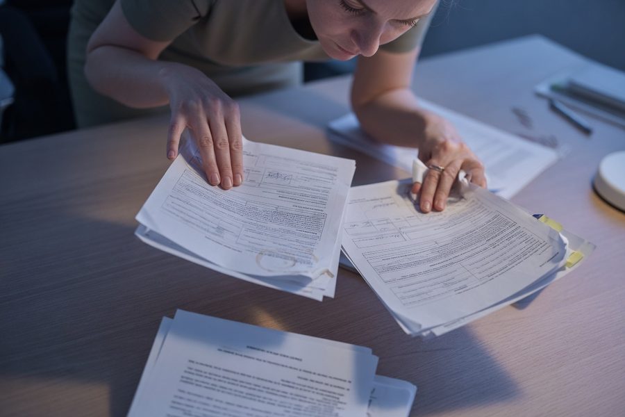 Person reviewing list of monthly obligations with calculator